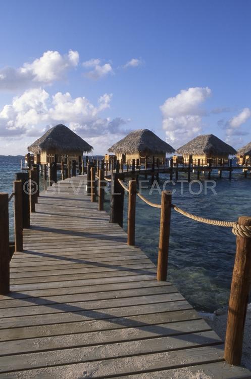 Islands;ocean;palm trees;blue;water;sky;manihi;french polynesia;pier;huts